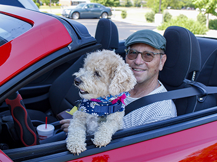 man and dog in car